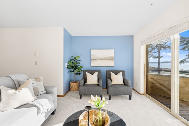 living room with a water view and light carpet