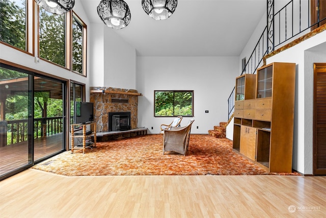 living room featuring hardwood / wood-style floors, a towering ceiling, and a fireplace