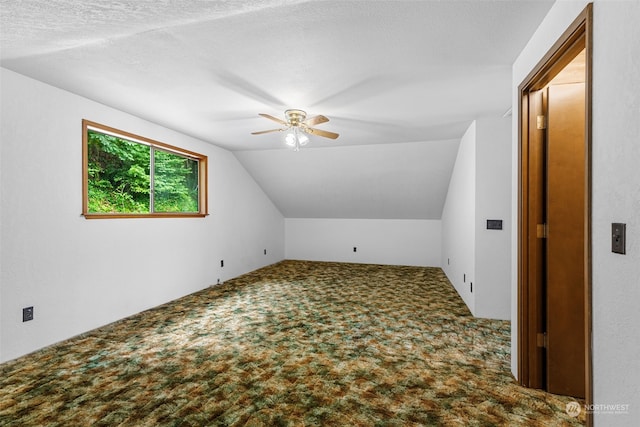 additional living space with lofted ceiling, ceiling fan, carpet floors, and a textured ceiling