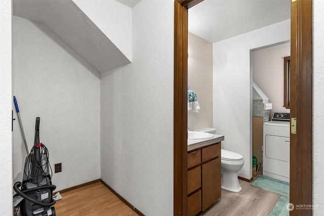 bathroom with washer / clothes dryer, vanity, hardwood / wood-style floors, and toilet