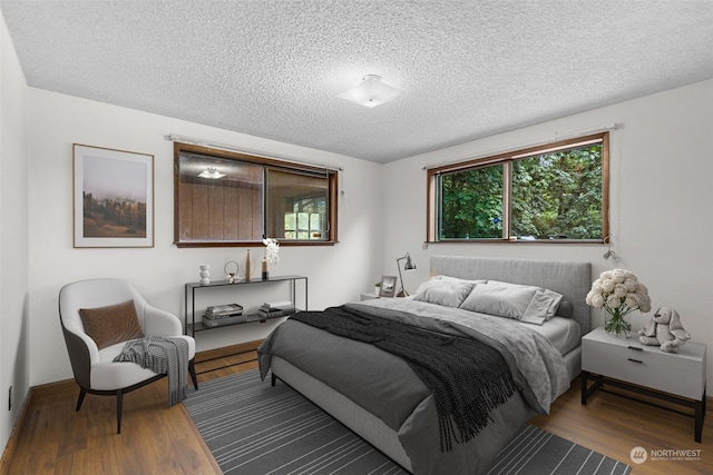 bedroom with hardwood / wood-style flooring and a textured ceiling