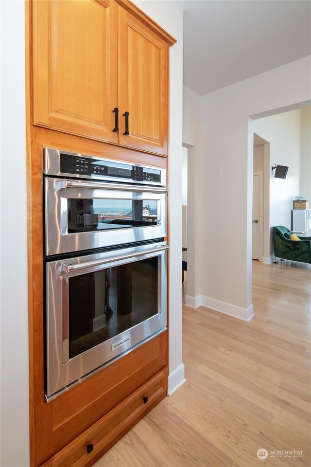 kitchen featuring light hardwood / wood-style flooring, double oven, and light brown cabinets