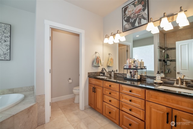 bathroom featuring double vanity, toilet, tile patterned floors, and tiled bath