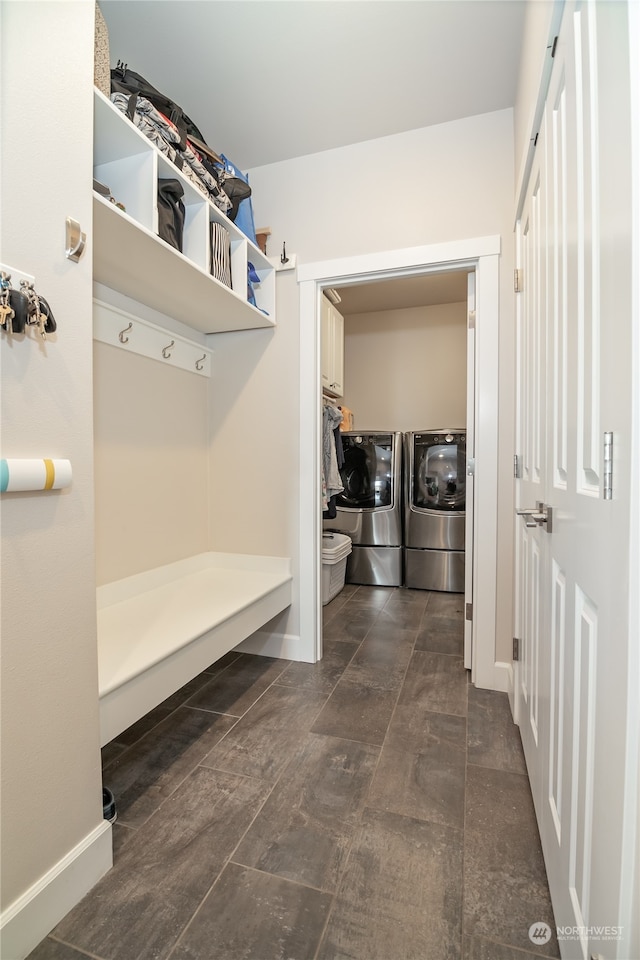 mudroom featuring independent washer and dryer and dark tile patterned flooring