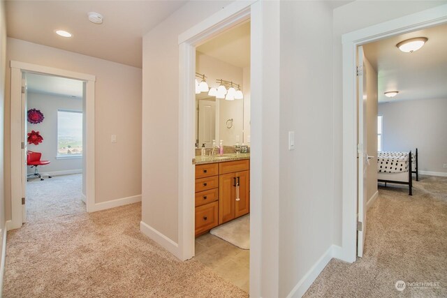 corridor with sink and light carpet