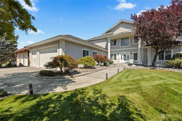 view of front of house with driveway, a garage, a front yard, and stucco siding