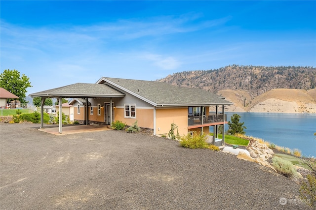 view of front facade featuring a balcony and a water and mountain view