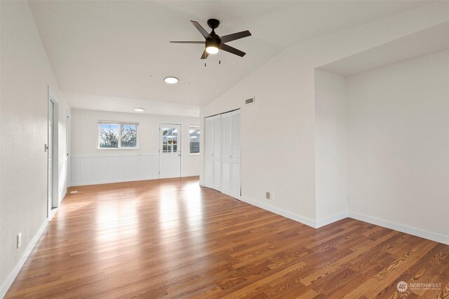 empty room with vaulted ceiling, hardwood / wood-style floors, and ceiling fan