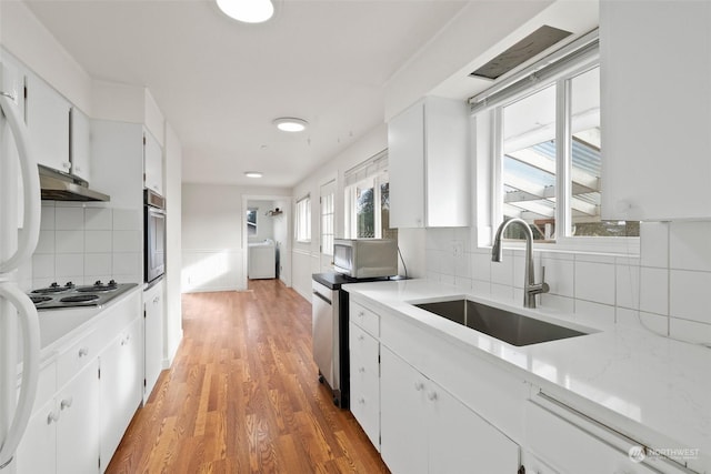 kitchen with sink, gas stovetop, oven, and white cabinets