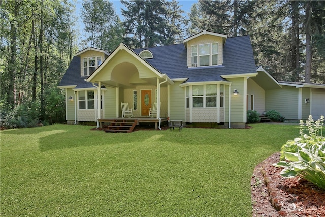 rear view of house with a porch and a lawn