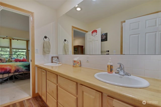 bathroom with vanity, wood-type flooring, and backsplash