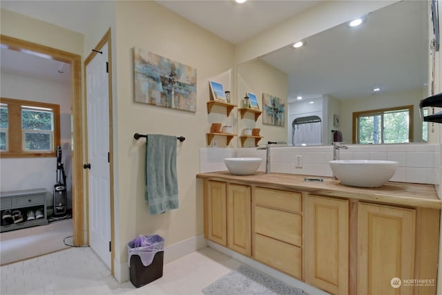 bathroom with vanity, decorative backsplash, and tile patterned floors