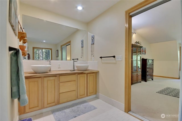 bathroom with vanity and lofted ceiling