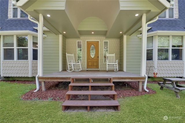 property entrance with a porch and a yard