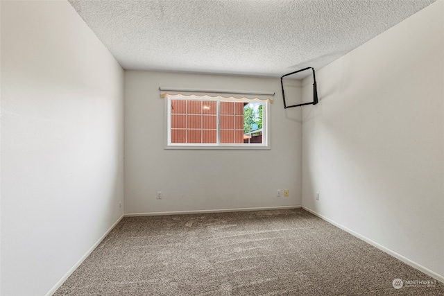 carpeted empty room with a textured ceiling