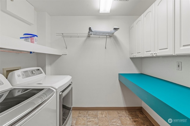 washroom with washer and clothes dryer and cabinets