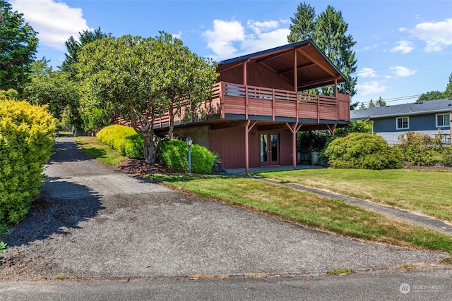 view of front of property with a front yard and a deck