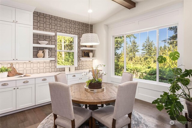 dining room with lofted ceiling with beams, dark hardwood / wood-style floors, and a wealth of natural light