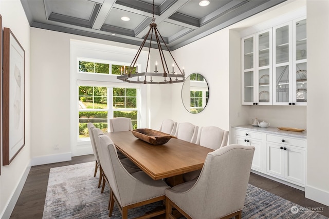 dining room featuring dark hardwood / wood-style flooring, coffered ceiling, crown molding, a notable chandelier, and beamed ceiling