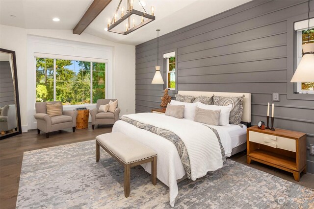 bedroom featuring lofted ceiling with beams, wood walls, dark wood-type flooring, and an inviting chandelier