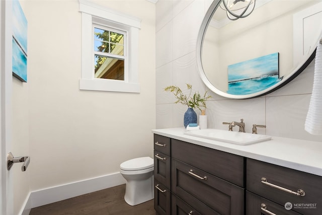 bathroom featuring vanity, wood-type flooring, and toilet