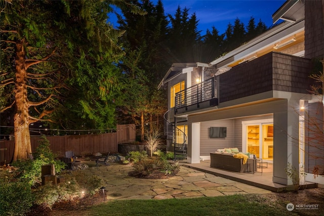 back of property featuring an outdoor living space, a patio, and a balcony