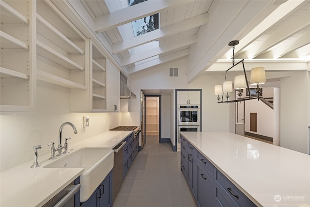 kitchen with blue cabinets, lofted ceiling with skylight, stainless steel appliances, and tile patterned floors