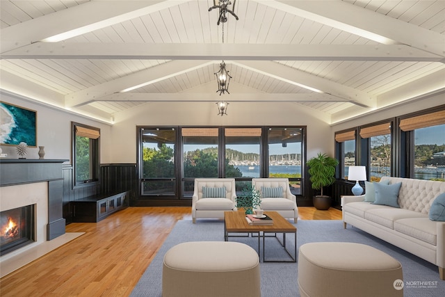 living room featuring plenty of natural light, light hardwood / wood-style floors, and lofted ceiling with beams