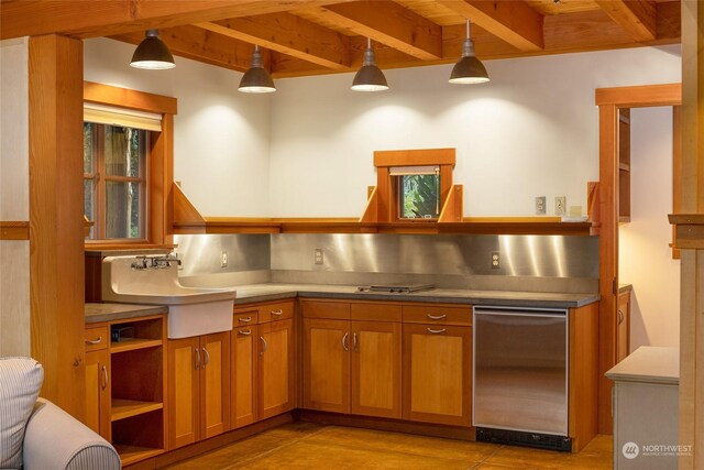 470 Friday Ave, Friday Harbor, WA 98250 - kitchen with beamed ceiling, brown cabinetry, a sink, and refrigerator