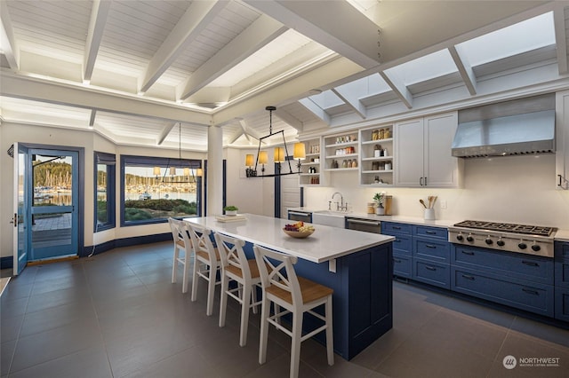 470 Friday Ave, Friday Harbor, WA 98250 - kitchen featuring a breakfast bar, open shelves, appliances with stainless steel finishes, blue cabinets, and premium range hood