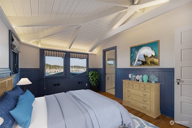 bedroom featuring ceiling fan, hardwood / wood-style flooring, and vaulted ceiling with beams