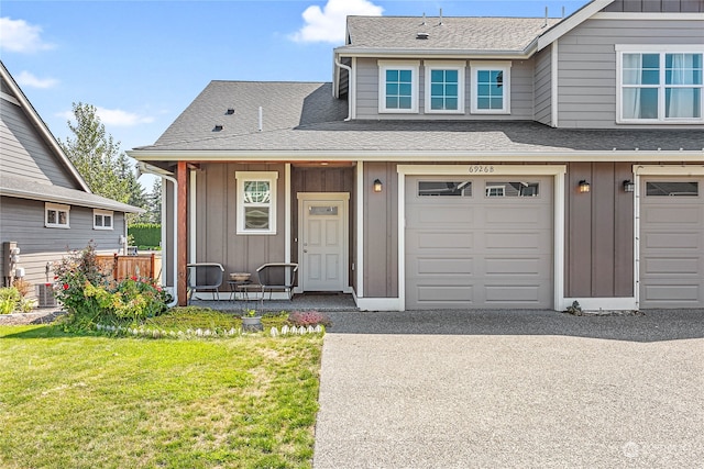 view of front of home featuring a garage, central AC unit, and a front yard