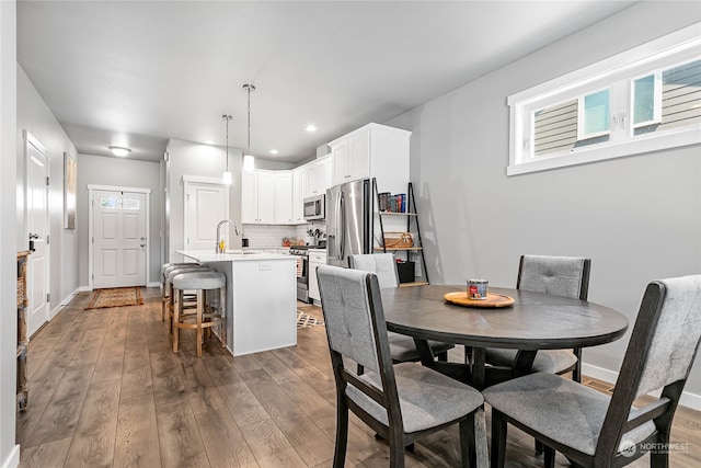 dining space featuring sink and wood-type flooring