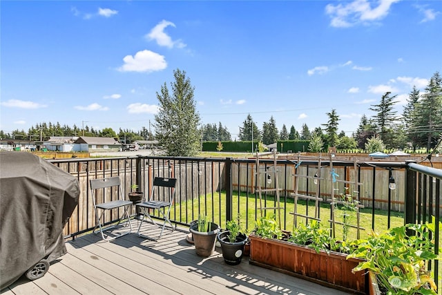 deck featuring grilling area and a lawn