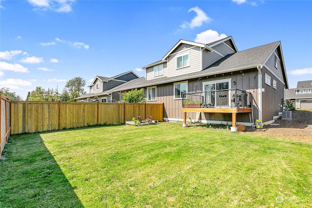 back of property with a wooden deck and a yard