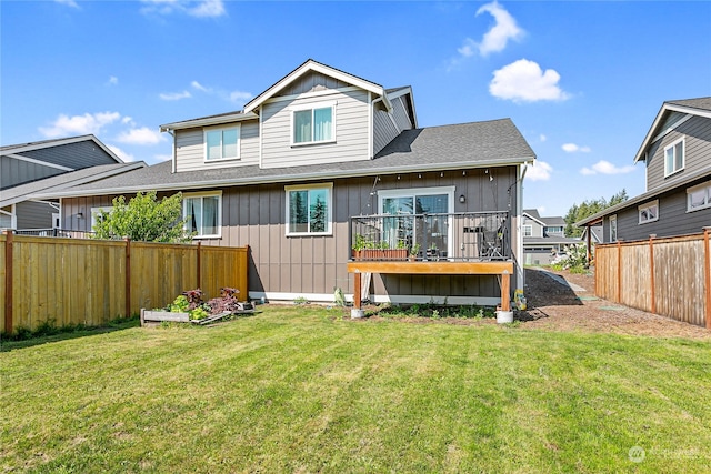 back of house featuring a wooden deck and a lawn