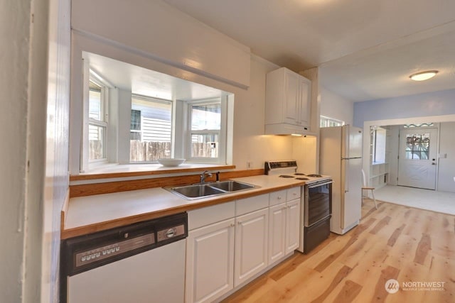 kitchen featuring sink, white cabinetry, light hardwood / wood-style flooring, and white appliances