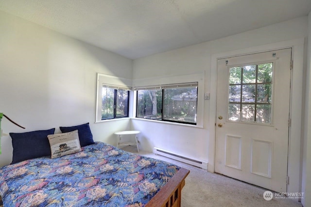 carpeted bedroom featuring a baseboard radiator, multiple windows, and a textured ceiling