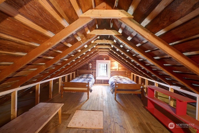 unfurnished bedroom with wood-type flooring and vaulted ceiling