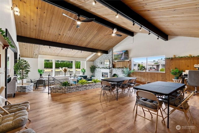 interior space with wooden ceiling, a brick fireplace, wood finished floors, and beamed ceiling