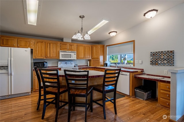 935 Sunrise Dr, Manson, WA 98831 - kitchen with white appliances, vaulted ceiling, tile counters, a sink, and light wood-type flooring