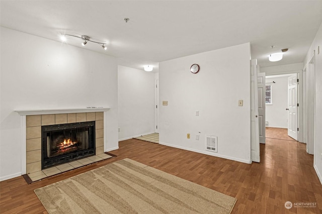 unfurnished living room featuring a fireplace and wood-type flooring