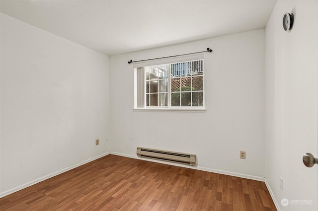 unfurnished room with hardwood / wood-style floors and a baseboard radiator