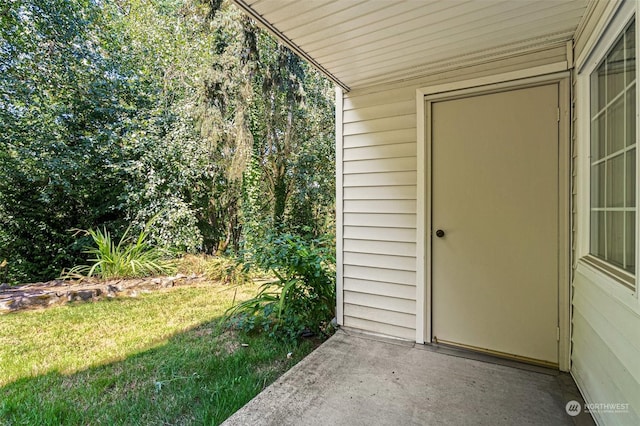 doorway to property with a yard