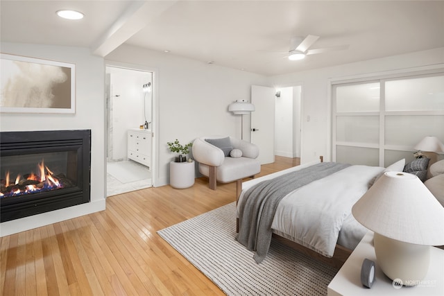 bedroom featuring ensuite bath, light hardwood / wood-style flooring, and ceiling fan