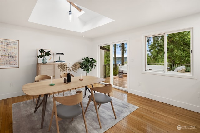 office with hardwood / wood-style flooring and a skylight