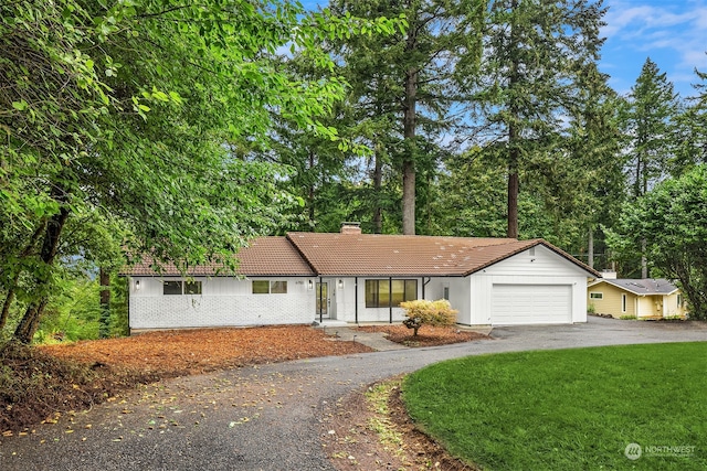 ranch-style house with a garage and a front lawn