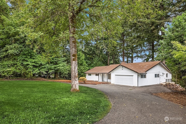 view of front of property with a front yard and a garage