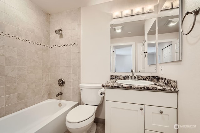 full bathroom with vanity, tiled shower / bath combo, and toilet