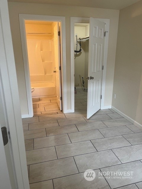 interior space with light wood-type flooring, a walk in closet, a closet, and connected bathroom